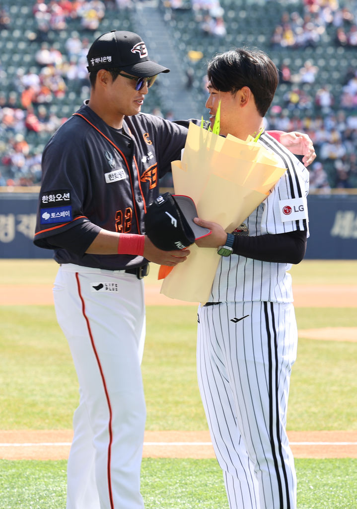 [서울=뉴시스] 정병혁 기자 = 24일 서울 송파구 잠실야구장에서 열린 2024 신한 SOL 뱅크 KBO리그 공식 개막전 한화 이글스와 LG 트윈스의 경기에 앞서 열린 LG 정주현 은퇴식에서 정주현이 한화 채은성에게 꽃다발을 받고 있다.(사진=LG 트윈스 제공) 2024.03.24. photo@newsis.com *재판매 및 DB 금지