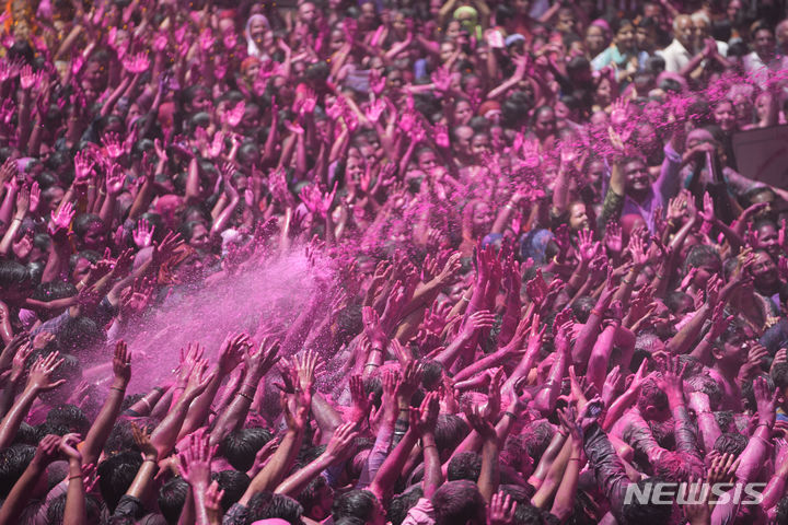 [아메다바드=AP/뉴시스] 25일(현지시각) 인도 아메다바드 칼루푸르 스와미나라얀 사원에서 열린 홀리 축제에 참가한 참가자들이 환호하고 있다. 2024.03.26.