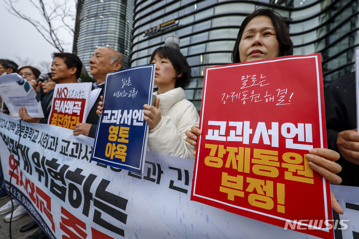 [서울=뉴시스] 정병혁 기자 = 아시아평화와역사교육연대와 아시아평화와역사연구소 관계자들이 25일 서울 종로구 주한일본대사관 앞에서 열린 2024 채택 중학교 사회과 교과서 검정 결과에 대한 긴급 기자회견에서 피켓을 들고 있다. 2024.03.25. jhope@newsis.com
