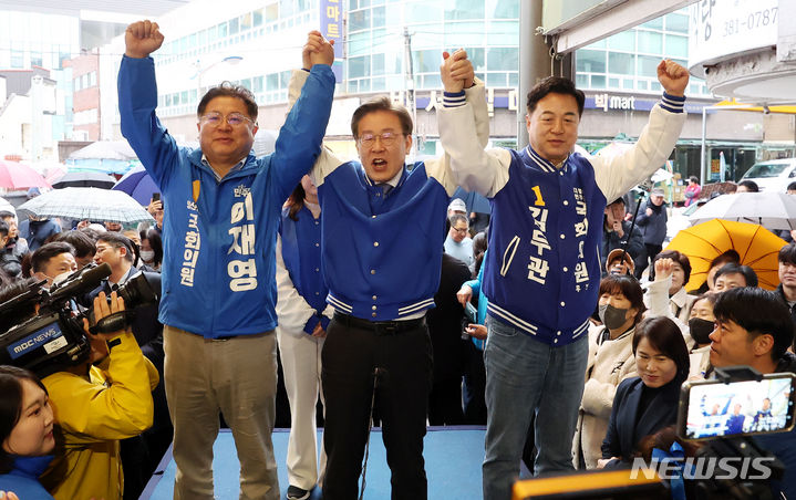 [양산=뉴시스] 추상철 기자 = 이재명 더불어민주당 대표가 25일 오후 경남 양산시 남부시장을 방문해 제22대 총선 이재영(왼쪽) 양산시갑 후보, 김두관(오른쪽) 양산시을 후보와 함께 시민들에게 인사를 하고 있다. 2024.03.25. scchoo@newsis.com