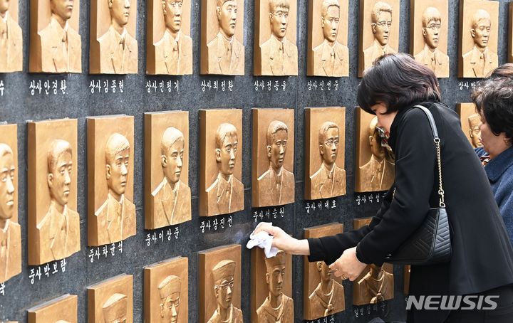 [평택=뉴시스] 김종택기자 = 제14주기 천안함 46용사 추모식이 거행된 26일 경기도 평택시 해군 제2함대사령부에서 유가족들이 추모비에 새겨진 얼굴을 어루만지고 있다. 이날 추모식에는 유가족, 천암함 피격사건 참전장병, 2함대 장병 및 군무원 등 200여 명이 참석했다. 2024.03.26. jtk@newsis.com