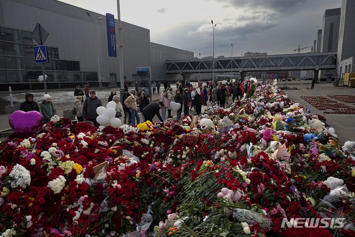 [모스크바=AP/뉴시스] 지난해 3월26일(현지시각) 러시아 모스크바 외곽 크로쿠스 시청 테러 현장 인근에 마련된 추모소에서 시민들이 꽃과 장난감을 놓으며 희생자들을 애도하고 있다. (사진=뉴시스DB)