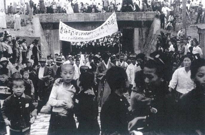 [서울=뉴시스] 3·15의거 시위대가 부림시장을 거쳐 구 북마산파출소 앞을 지나 당시 철로길 밑 거리로 행진하고 있다. (사진=2기 진실·화해를위한과거사정리위원회 제공) 2024.03.27. photo@newsis.com *재판매 및 DB 금지