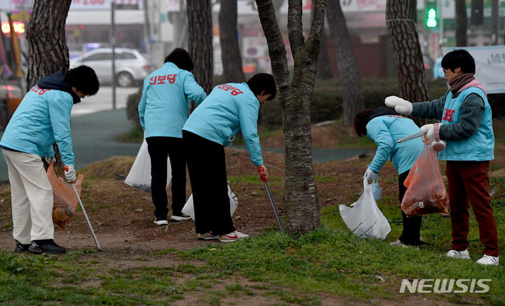 [광주=뉴시스] 변재훈 기자 = 27일 오전 광주 북구 양산동 양산호수공원 일대에서 단체복을 입은 진보당 당원들이 쓰레기를 줍고 있다. 2024.03.27. wisdom21@newsis.com