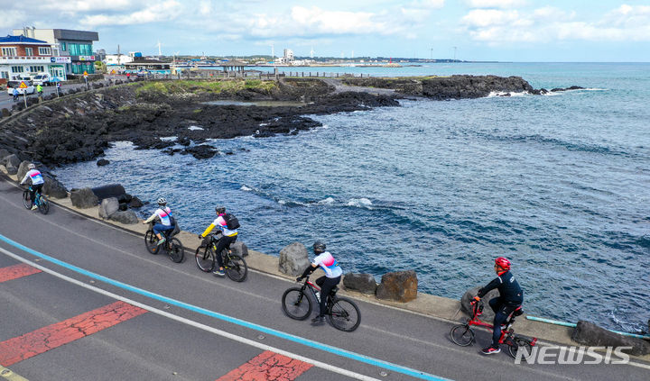 [제주=뉴시스] 우장호 기자 = 싱가포르 '샹그릴라 사이클링 투어(SCT)' 동호회원들이 27일 오전 제주시 구좌읍 해안도로를 자전거로 일주하고 있다. 제주관광공사와 제주도는 해외 관광객들이 더 오래 머물며 제주를 즐길 수 있도록 낚시와 오름, 골프 등 특수목적 상품을 추가 개발할 계획이다. 2024.03.27. woo1223@newsis.com