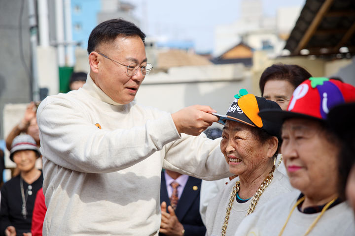 김재욱 군수가 텃밭 왕언니 힙합그룹 창단식에서 할머니들에게 모자를 씌워주고 있다 (사진=칠곡군 제공) *재판매 및 DB 금지