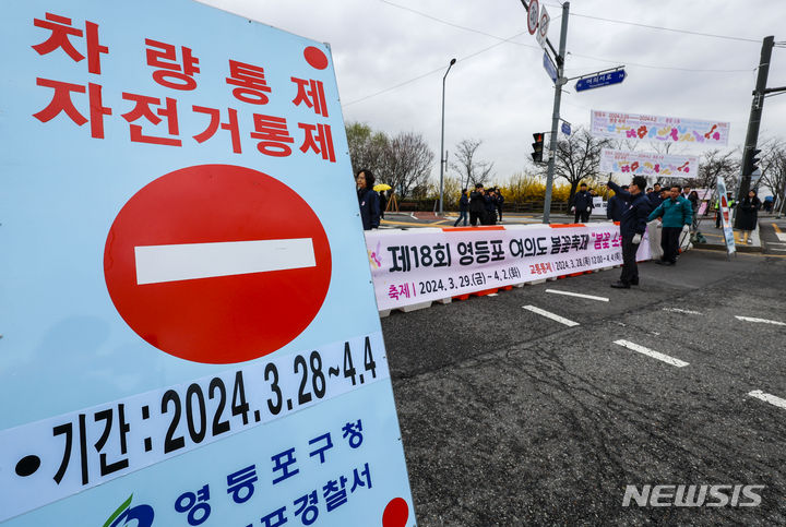 [서울=뉴시스] 정병혁 기자 = 여의도봄꽃축제 개막을 하루 앞둔 28일 서울 영등포구 여의서로에서 작업자들이 차량통제 바리케이트와 안내판을 설치하고 있다. 영등포구는 29일부터 오는 4월 2일까지 여의서로 국회뒷편 일대에서 영등포 여의도봄꽃축제를 개최한다. 2024.03.28. jhope@newsis.com