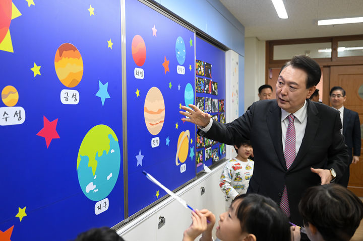 [서울=뉴시스] 윤석열 대통령이 29일 경기도 화성 아인초등학교에서 늘봄학교 초1 맞춤형 프로그램이 진행 중인 교실을 방문해 학생들에게 행성계에 대해 설명해주고 있다. (사진=대통령실 제공) 2024.03.29. photo@newsis.com *재판매 및 DB 금지