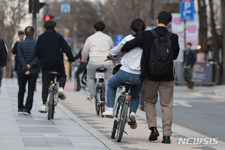 [서울=뉴시스] 권창회 기자 = 전국 낮 기온이 15~20도까지 올라 포근한 날씨를 보인 지난달 31일 오후 서울 중구 청계천 인근에서 한 커플이 자전거 타는 법을 배우고 있다. 2024.03.31. kch0523@newsis.com