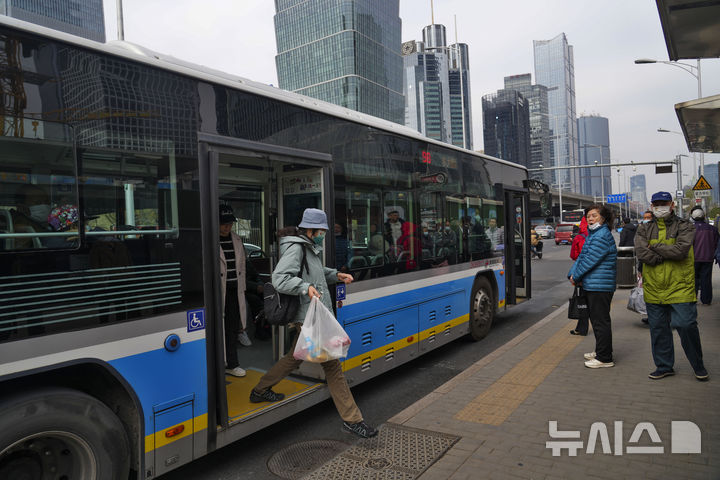 [베이징=AP/뉴시스] 베이징 중심 상업지구에서 한 승객이 시내버스에서 내리고 있다. 2024.04.01.