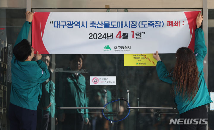 [대구=뉴시스] 이무열 기자 = 대구 북구 검단동 축산물도매시장(일명 대구도축장) 폐쇄가 집행되는 1일 안중곤 대구시 경제국장이 시설 폐쇄 안내문을 부착하고 있다. 2024.04.01. lmy@newsis.com
