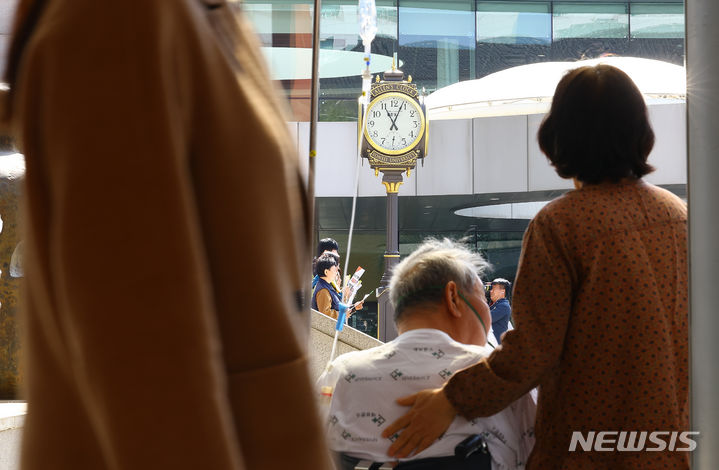 [서울=뉴시스] 김근수 기자 = 자난 1일 서울 서대문구 신촌 세브란스 병원 앞에서 한 입원 환자가 서울지역 전공의 수련병원 노동조합 대표자 합동 기자회견을 바라보고 있는 모습. 2024.04.01. ks@newsis.com