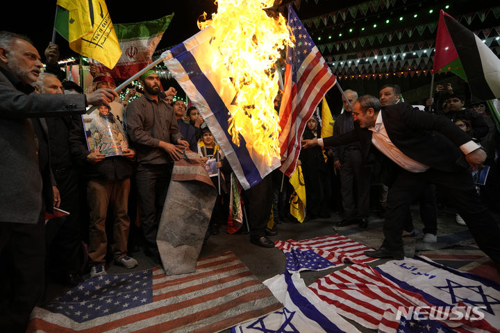 [테헤란=AP/뉴시스] 이스라엘의 주시리아 이란 영사관 공격을 규탄하는 시위대가 지난 1일(현지시간) 이란 수도 테헤란에서 미국과 이스라엘 국기를 불태우고 있다. 2024.04.04.