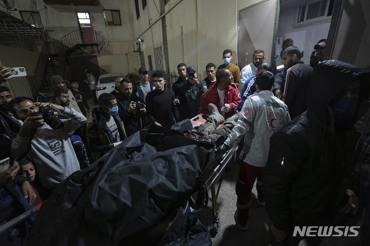 [데이르알발라=AP/뉴시스] 1일(현지시각) 가자지구 중부 데이르알발라에서 팔레스타인 주민들이 이스라엘 공습으로 사망한 이들의 시신을 옮기고 있다. 가자지구 의료 관계자들은 이날 구호품을 전달하던 월드센트럴키친 소속 외국인 4명과 팔레스타인 운전기사 1명이 사망했다고 밝혔다. 2024.04.02.