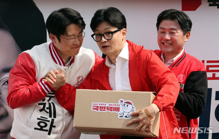 [세종=뉴시스] 강종민 기자 = 한동훈 국민의힘 비상대책위원장이 2일 세종시 나성동에서 열린 세종살리기 집중지원유세에서 세종시 출마자들에게 국민택배를 전달하고 있다. 2024.04.02. ppkjm@newsis.com