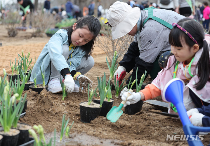 [서울=뉴시스] 김진아 기자 =서울 강동구 암사역사공원 일대에서 열린 제79회 식목일 기념 동행매력 정원도시 서울 만들기 행사에서 어린이들이 꽃을 심고 있다. 2024.04.02. bluesoda@newsis.com