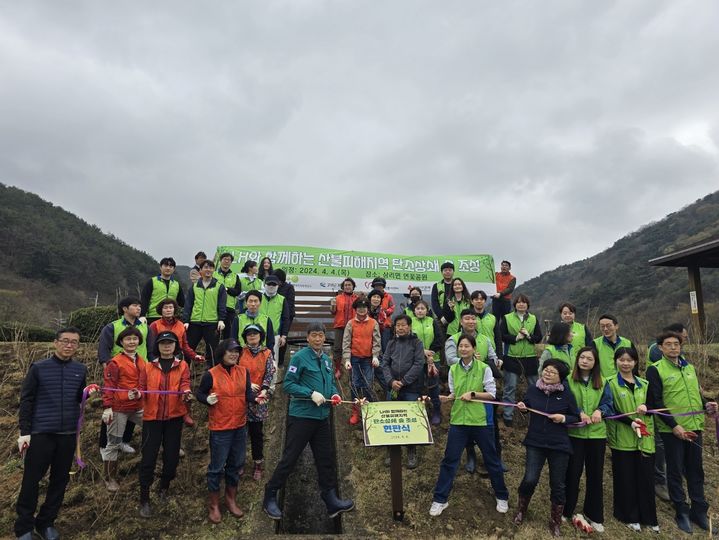 [고성(경남)=뉴시스] 신정철 기자= 경남 고성군은 4일 상리면 연꽃공원 일원에서 한국토지주택공사와 경상남도자원봉사센터, 경남사회복지공동모금회, 고성군자원봉사단체협의회 임직원 및 자원봉사자 70여 명이 참여한 가운데 ‘LH와 함께하는 탄소상쇄 숲 조성 식목 행사’를 진행했다.사진은 탄소상쇄 숲 조성 현판식 모습.(사진=고성군 제공).2024.04.04. photo@newsis.com *재판매 및 DB 금지