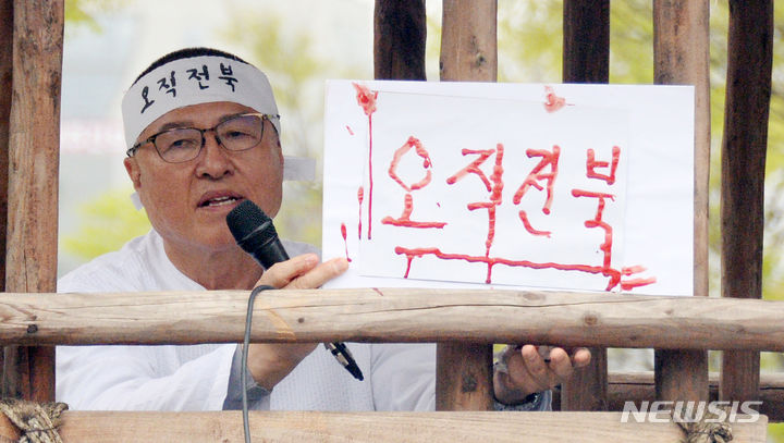 [전주=뉴시스] 김얼 기자 = 정운천 국민의힘 전북 전주시을 선거구 국회의원 후보가 4일 전북 전주시 전북특별자치도청 앞 광장에서 기자회견을 열고 혈서로 쓴 '오직전북'을 들고 질의에 답변하고 있다. 2024.04.04. pmkeul@newsis.com