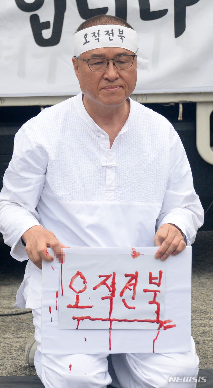 [전주=뉴시스] 김얼 기자 = 정운천 국민의힘 전북 전주시을 선거구 국회의원 후보가 4일 전북 전주시 전북특별자치도청 앞 광장에서 기자회견을 열고 혈서로 쓴 '오직전북'을 들고 있다. 2024.04.04. pmkeul@newsis.com