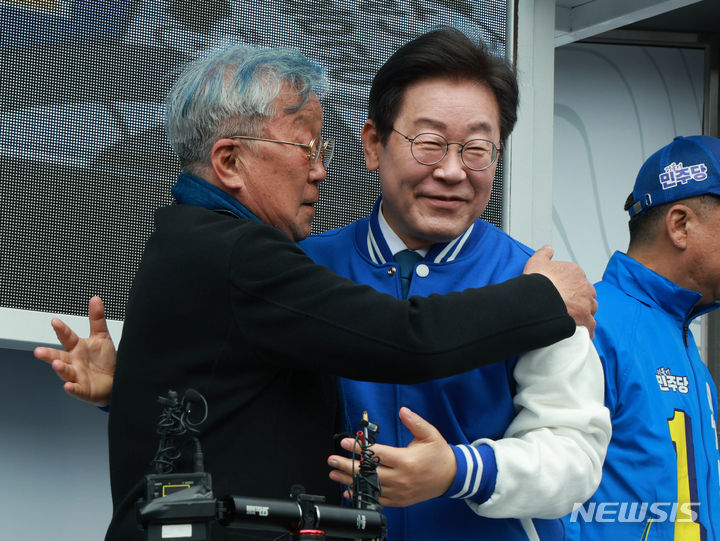 [부산=뉴시스] 이재명 더불어민주당 대표가 지난 2024년 4월 4일 부산 수영구 올리브영 부산수영로점 옆에서 유동철 수영구 후보 지지유세를 하기 전 배우 명계남과 포옹하는 모습. 2024.04.04. photo@newsis.com