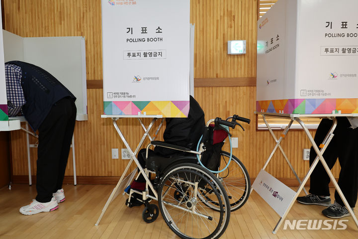 [서울=뉴시스] 김명년 기자 = 제22대 국회의원 선거 사전투표 첫 날인 지난해 4월 5일 서울 광진구 구의제1동 주민센터에 마련된 사전투표소에서 휠체어를 탄 유권자가 기표를 하고 있다. 기사 내용과 관계 없음. 2024.04.05. kmn@newsis.com