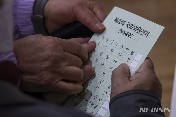 [서울=뉴시스] 정병혁 기자 = 제22대 국회의원선거 사전투표 첫 날인 5일 서울 성동구 왕십리 도선동 공공복합청사에 마련된 사전투표소를 찾은 한 시각장애인이 점자 투표지를 읽고 있다. 2024.04.05. jhope@newsis.com