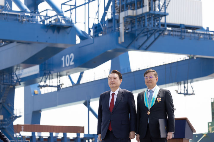 [창원=뉴시스] 윤석열 대통령이 5일 경남 창원시 진해구 부산항 신항에서 열린 7부두 개장식에서 김남정 동원그룹 회장에게 은탑산업훈장을 수여한 뒤 기념촬영 하고 있다. (사진=대통령실 제공) 2024.04.05. photo@newsis.com *재판매 및 DB 금지