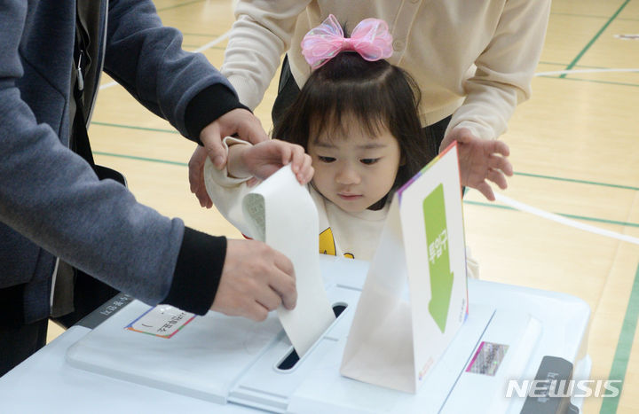 [전주=뉴시스] 김얼 기자 = 제22대 국회의원선거 사전투표 둘째 날인 6일 전북 전주시 덕진구 송천동 에코데시앙 7블럭아파트에 설치된 사전투표소에서 한 어린이가 부모와 함께 투표를 하고 있다. 2024.04.06. pmkeul@newsis.com