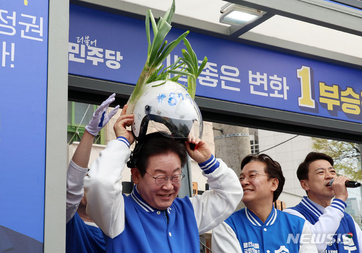 [용인=뉴시스] 이영환 기자 = 이재명 더불어민주당 대표가 지난 6일 오후 경기 용인시 수지구 풍덕천사거리에서 열린  부승찬 용인병 후보 지원유세에서 지지자가 가지고 온 대파 헬멧을 착용하고 있다. 2024.04.06. 20hwan@newsis.com