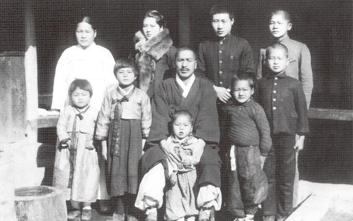 [서울=뉴시스]1940년대 수원 평동 7번지 한옥 앞. 최학배 공(사진 가운데), 이동대 여사(사진 뒷줄 왼쪽), 어린 시절 최종건 SK 창업회장(사진 뒷줄 오른쪽), 최종현 선대회장(사진 두번째줄 오른쪽). (사진 = SK) 2024.04.08. photo@newsis.com&nbsp; *재판매 및 DB 금지