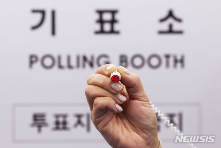 [서울=뉴시스] 정병혁 기자 = 제22대 국회의원 선거를 하루 앞둔 9일 서울 영등포구 YDP미래평생학습관에 설치된 투표소에서 선거사무원이 기표용구를 들어보이고 있다. 2024.04.09. jhope@newsis.com