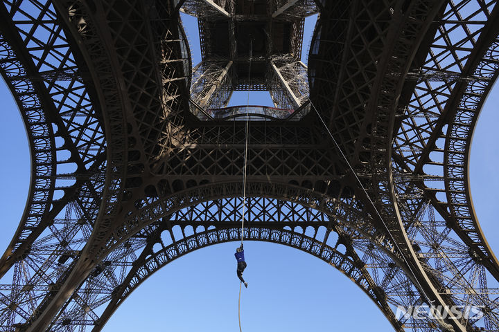 [파리=AP/뉴시스] 아누크 가르니에(34)가 10일(현지시각) 로프 클라이밍 세계기록을 경신했다고 가디언 등이 이날 보도했다. 사진은 에펠탑에서 110m를 오르고 있는 가르니에. 2024.04.11.