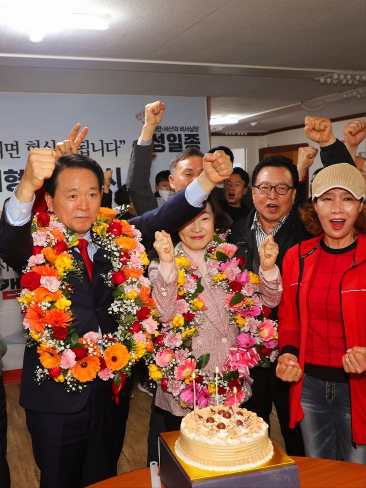 [서산태안=뉴시스] 지난 10일 서산태안 선거구 국민의힘 성일종 후보가 22대 총선 개표 결과 당선이 확정되자 자신의 선거 캠프에서 배우자와 함께 화환을 목에 건 채 만세를 부르고 있다.(사진=성일종 후보 선거 캠프 제공) 2024.04.11 *재판매 및 DB 금지