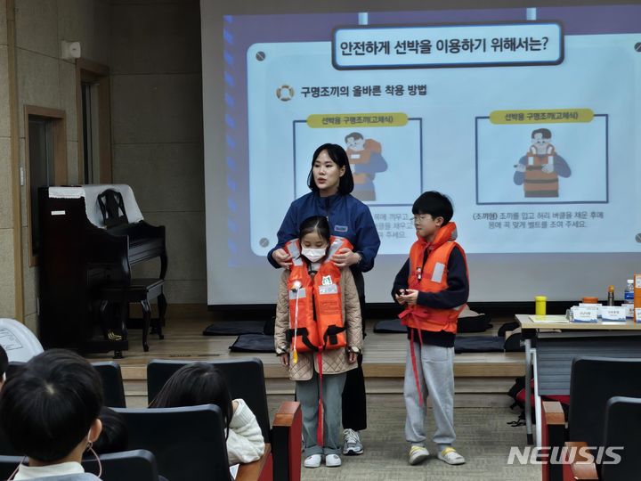 [서울=뉴시스] 한국해양교통안전공단(KOMSA)의 '찾아가는 해양안전교실'에 참여한 학생들이 어린이용 구명조끼를 실제로 착용해 보고 있다.
