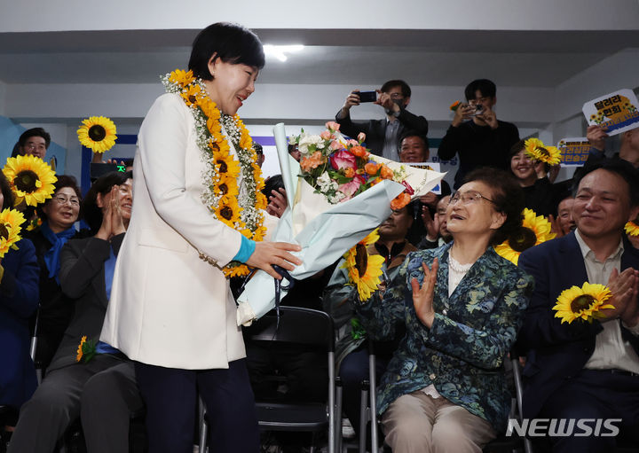 [서울=뉴시스] 김진아 기자 = 전현희 더불어민주당 중·성동갑 후보가 11일 서울 성동구 왕십리로에 마련된 선거사무실에서 당선이 확실시되자 어머니에게 꽃다발을 드리고 있다. 2024.04.11. bluesoda@newsis.com