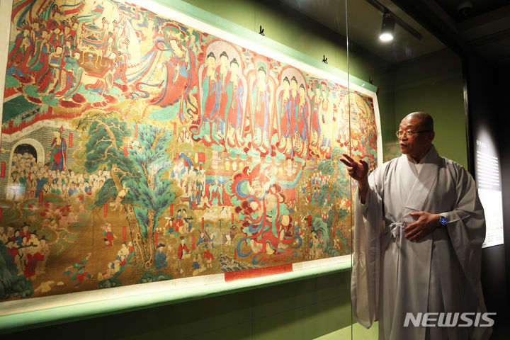 [서울=뉴시스] 박진희 기자 = 불교중앙박물관 관장 서봉스님이 지난 11일 서울 종로구 불교중앙박물관에서 인터뷰를 마치고 전시중인 화성 용주사 '감로도'를 설명하고 있다. 2024.04.13. pak7130@newsis.com