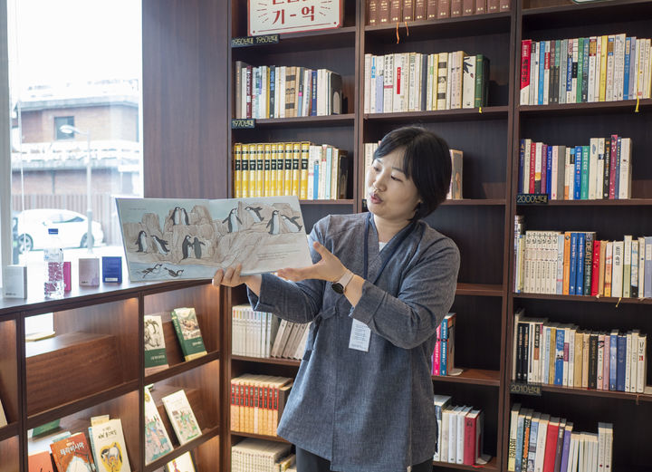 [전주=뉴시스] 강경호 수습기자 = 지난 6일 전북 전주시의 동문헌책도서관에서 박현 도서관 여행 해설사가 참가자들에게 그림책을 직접 읽으며 내용을 설명하고 있다. *재판매 및 DB 금지