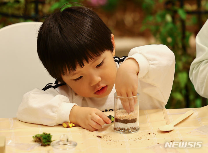 [서울=뉴시스] 김근수 기자 = 12일 서울 강남구 코엑스에서 열린 2024 대한민국 어린이박람회에서 한 어린이가 반려식물 만들기 체험을 하고 있다. 2024.04.12. ks@newsis.com