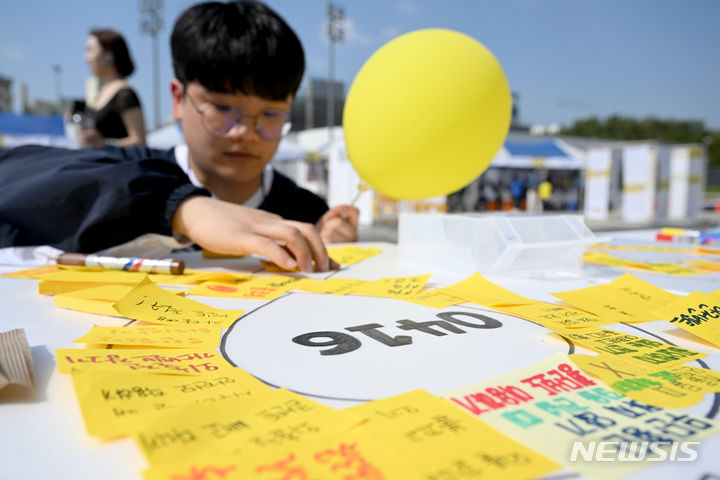 [광주=뉴시스] 김혜인 기자 = 세월호 참사 10주기를 사흘 앞두고 광주청소년 기억문화제가 열린 13일 오후 광주 동구 5·18민주광장에서 시민이 생활 속 안전 수칙 문구를 적고 있다. 2024.04.13. hyein0342@newsis.com