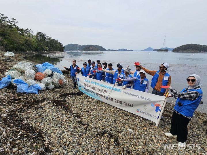 [통영=뉴시스]14일 경남외국인 자원봉사단 단원들이 '반려해변'으로 입양한 통영 통시해변에서 해양쓰레기 수거 봉사활동을 마친 후 기념촬영하고 있다.(사진=경상남도외국인주민지원센터 제공) 2024.04.14. photo@newsis.com