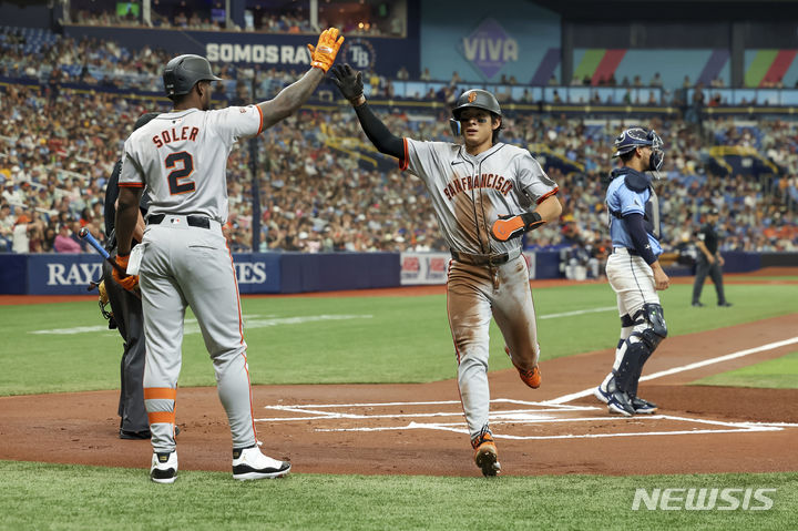 [세인트피터즈버그=AP/뉴시스] 샌프란시스코 자이언츠의 이정후가 15일(한국시각) 미국 플로리다주 세인트피터즈버그의 트로피카나필드에서 열린 2024 메이저리그(MLB) 탬파베이 레이스와의 경기에서 1회초 득점을 올리며 하이파이브를 하고 있다. 2024.04.15