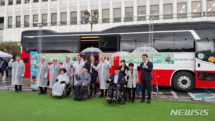 [창원=뉴시스]홍정명 기자=15일 오전 경남도청 중앙현관 앞 주차장에서 열린 '경상남도 장애인 세상보기 버스' 제막식에 참석한 박완수 도지사와 정쌍학 경남도의회 문화복지부위원장 등이 기념촬영하고 있다.2024.04.15. hjm@newsis.com