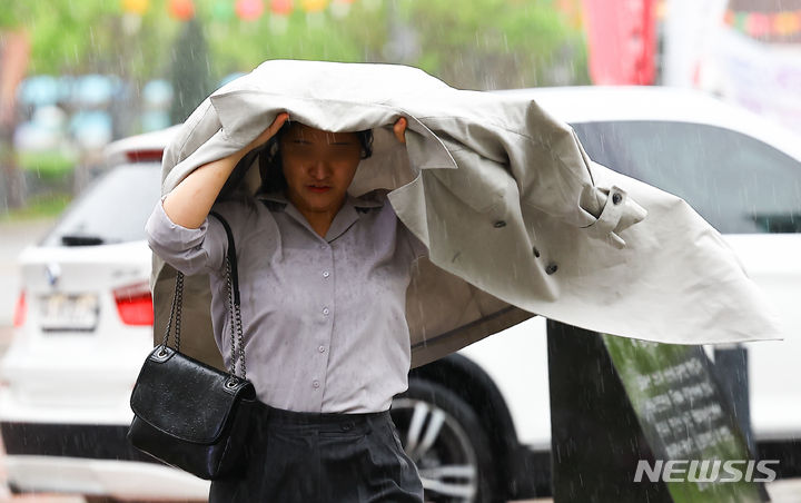 [서울=뉴시스] 김근수 기자 = 수요일인 24일은 전국이 대체로 흐린 가운데 대부분 지역에 비가 오겠다. 대기 불안정으로 싸락우박이 떨어지는 곳도 있겠다. 사진은 비가 내리던 지난 15일 서울 중구 세종대로에서 한 시민이 외투를 머리에 쓰고 출근하는 모습. 2024.04.15. ks@newsis.com