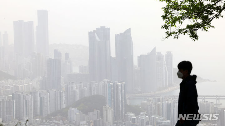 [부산=뉴시스] 하경민 기자 = 황사의 유입으로 부산 16개 구·군 모든 지역에 '미세먼지(PM-10) 주의보'가 발령된 17일 부산 황령산을 찾은 시민이 뿌옇게 변한 도심을 바라보고 있다. 2024.04.17. yulnetphoto@newsis.com