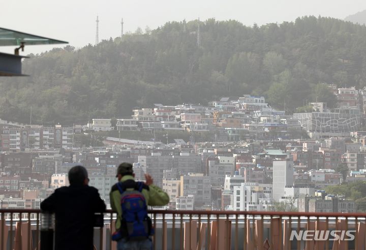 [부산=뉴시스] 하경민 기자 = 황사의 유입으로 부산 16개 구·군 모든 지역에 이틀째 '미세먼지(PM-10) 경보' 등이 발령된 지난 18일 부산 중구 롯데백화점 광복점 옥상 전망대를 찾은 시민들이 뿌옇게 변한 도심을 바라보고 있다. 2024.04.18. yulnetphoto@newsis.com