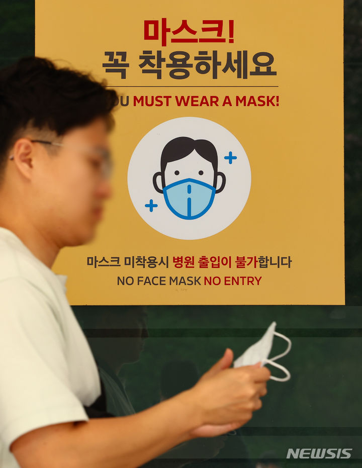 [서울=뉴시스] 황준선 기자 = 지난 19일 서울 시내 한 대형병원에 게시된 마스크 착용 안내문 앞으로 내원객이 이동하고 있다. 정부는 코로나19의 감염병 재난 위기단계를 오는 1일부터 '경계'에서 가장 낮은 단계인 '관심'으로 하향 조정한다. 따라서 병원급 의료기관과 입소형 감염취약시설에 한해 의무로 남아있던 마스크 착용이나 감염취약시설 입소자 대상 선제검사도 의무에서 권고로 바뀐다. 2024.04.30.