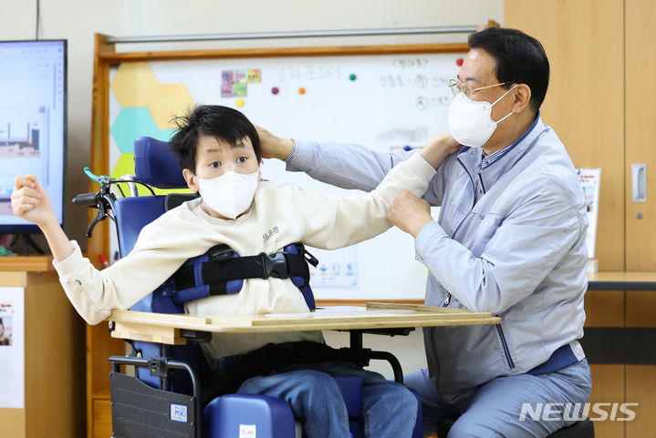 [서울=뉴시스] 황준선 기자 = 지난 19일 노원구 서울정민학교에서 활동지원사 김무선(가명)씨가 중증장애학생 보현이(가명)와 함께 포즈를 취하고 있다. 2024.04.20. hwang@newsis.com