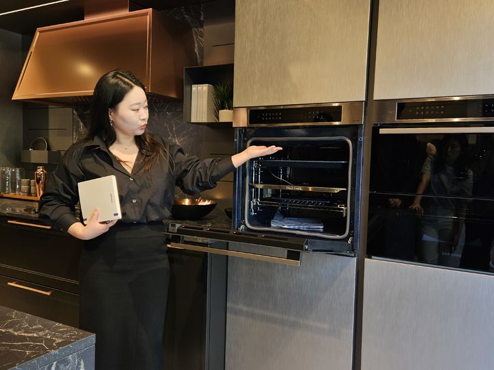 [밀라노=뉴시스]석혜미 삼성전자 이탈리아 법인 프로가 코르소 셈피오네(Corso Sempione) 지역 빌트인 명품 주방 가구 전문 브랜드 '루베(Lube)' 매장에 설치된 삼성전자 주방 가전에 대해 설명하고 있다. (사진 = 삼성전자) 2024.04.20. photo@newsis.com *재판매 및 DB 금지