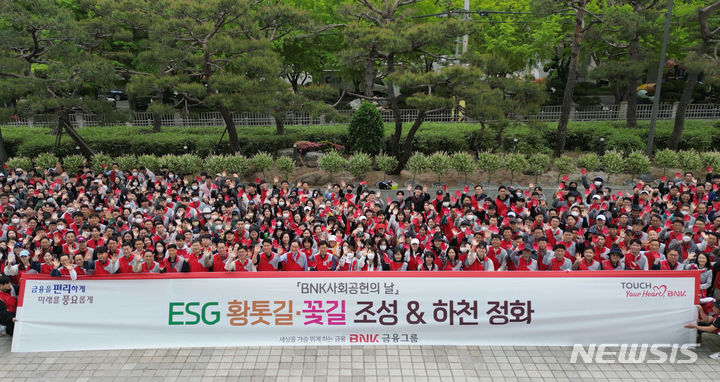 [창원=뉴시스]BNK금융그룹 빈대인 회장, BNK경남은행 예경탁 은행장 등 임직원들이 20일 경남 창원 산호천변 일원에서 'BNK사회공헌의 날' 행사를 진행한 후 기념촬영하고 있다.(사진=BNK경남은행 제공) 2024.04.20. photo@newsis.com