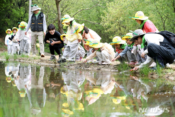 [광주=뉴시스] '환경의 날'인 22일 광주 북구 무등산국립공원 평두메습지에서 아이들이 습지에 서식하는 생물을 관찰하고 있다. 평두메습지는 묵논습지로 다양한 양서류를 비롯해 멸종위기 야생생물이 서식하고 있다. (사진 = 광주 북구 제공) 2024.04.22. photo@newsis.com *재판매 및 DB 금지